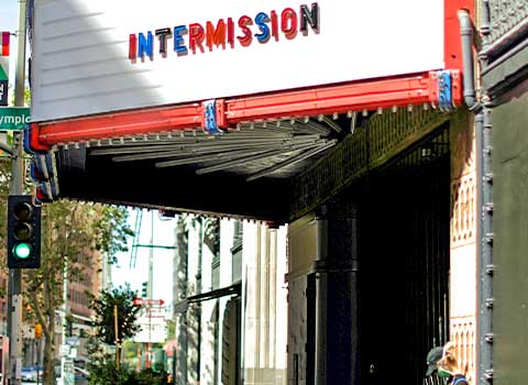 An image of the outside of a movie theater in Los Angeles. The theater’s marquee sign says ”INTERMISSION.” 