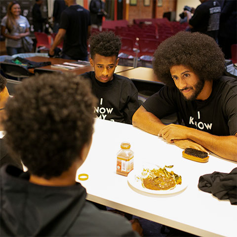 Colin Kaepernick talks with children in Oakland, CA.