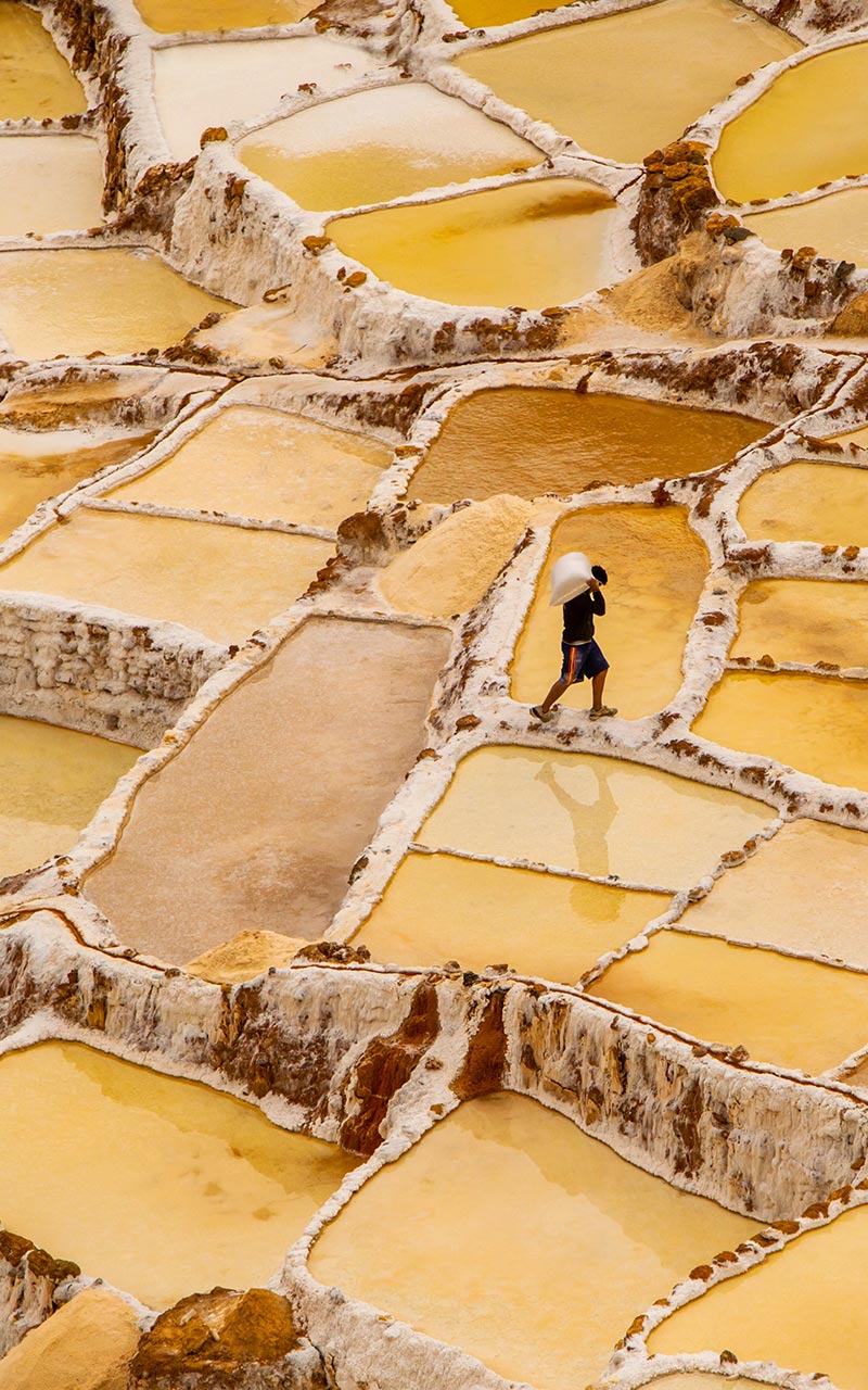 worker mining in yellow salt flats in Peru