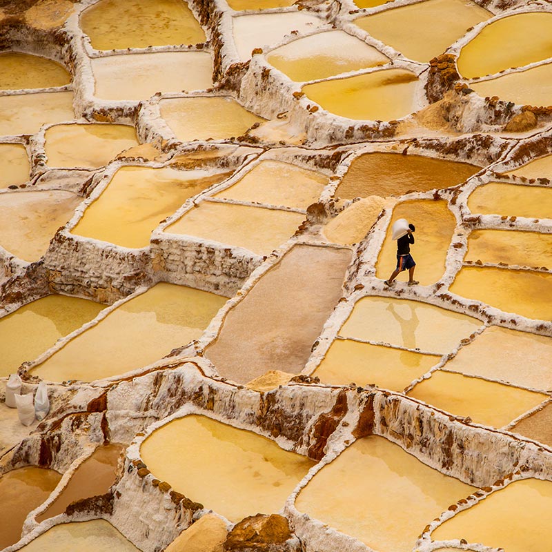 worker mining in yellow salt flats in Peru