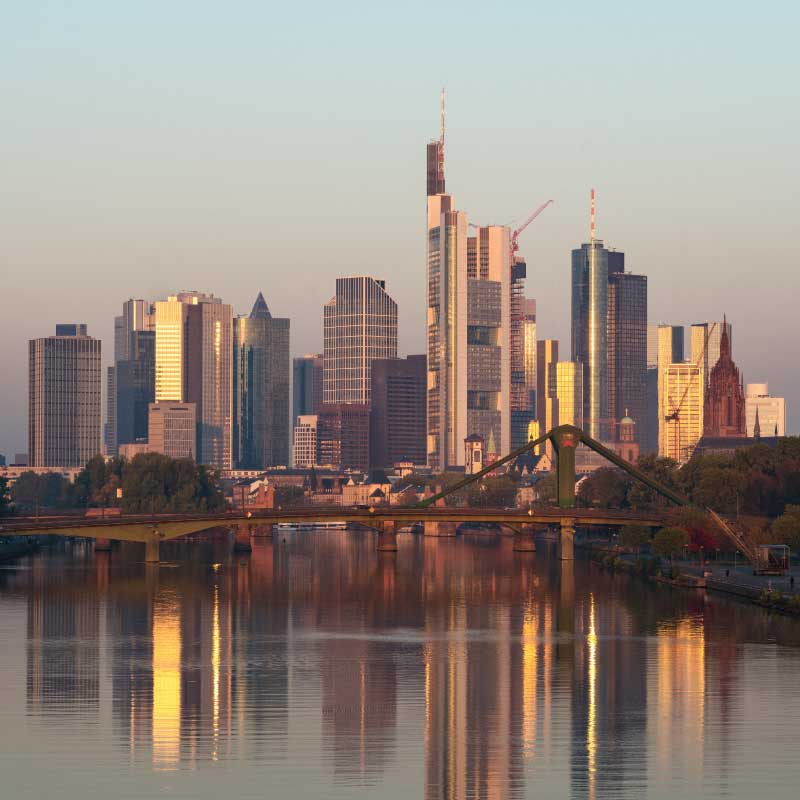 The skyline of Frankfurt is reflected on the river main at sunrise