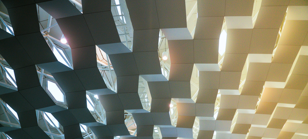 A closeup shows architectural details of a ceiling in Shanghai. It appears as if three-dimensional columns of blocks hang from the ceiling and reflect light. 