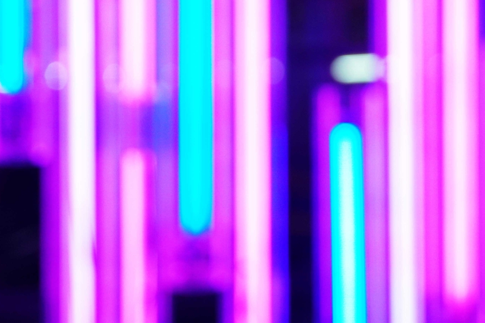 Blurred close-up of pink and turquoise neon lights