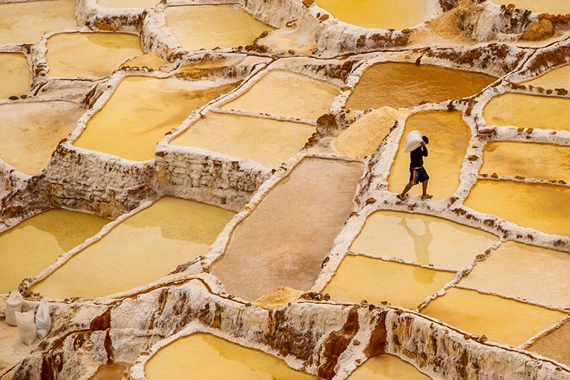 worker mining in yellow salt flats in Peru