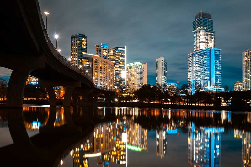 illuminated modern buildings by river