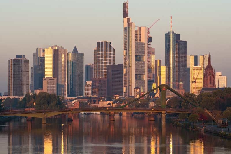 The skyline of Frankfurt is reflected on the river main at sunrise