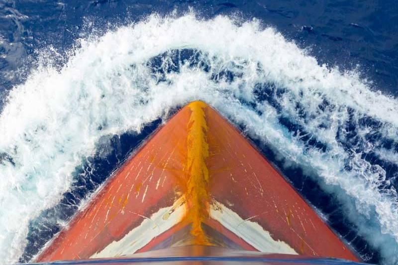 Aerial top down view of a motorboat traveling over blue sea