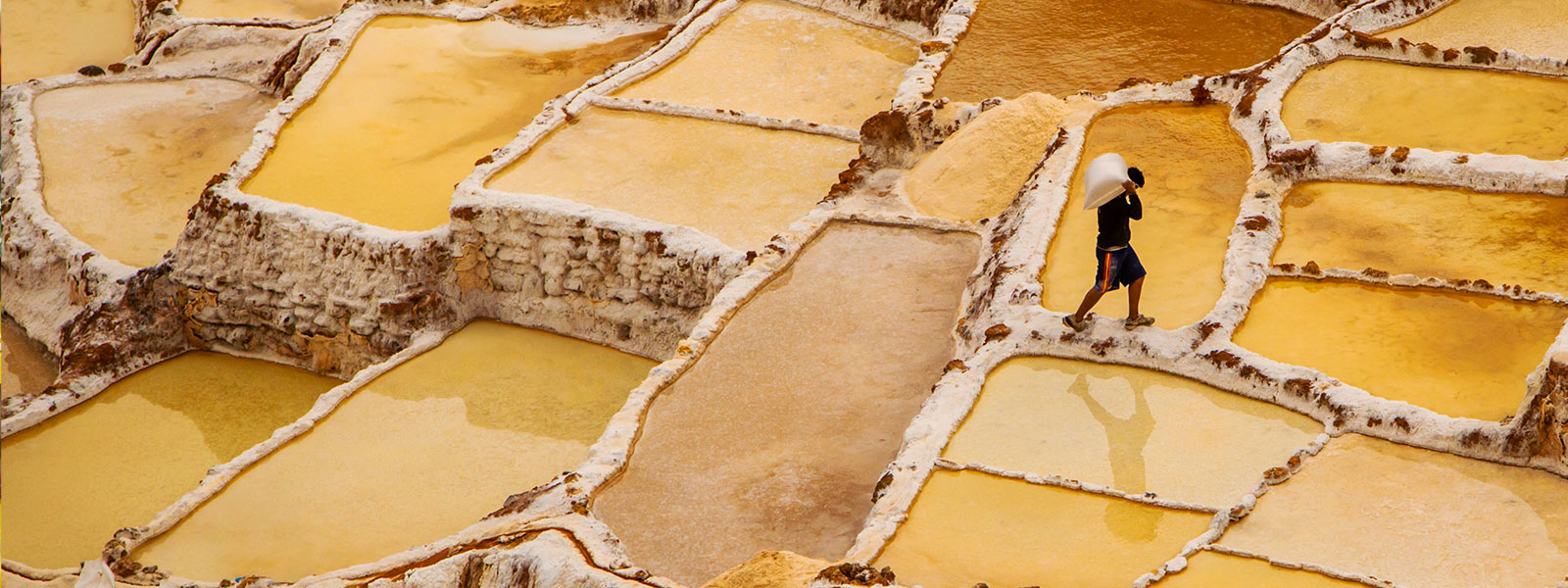 worker mining in yellow salt flats in Peru