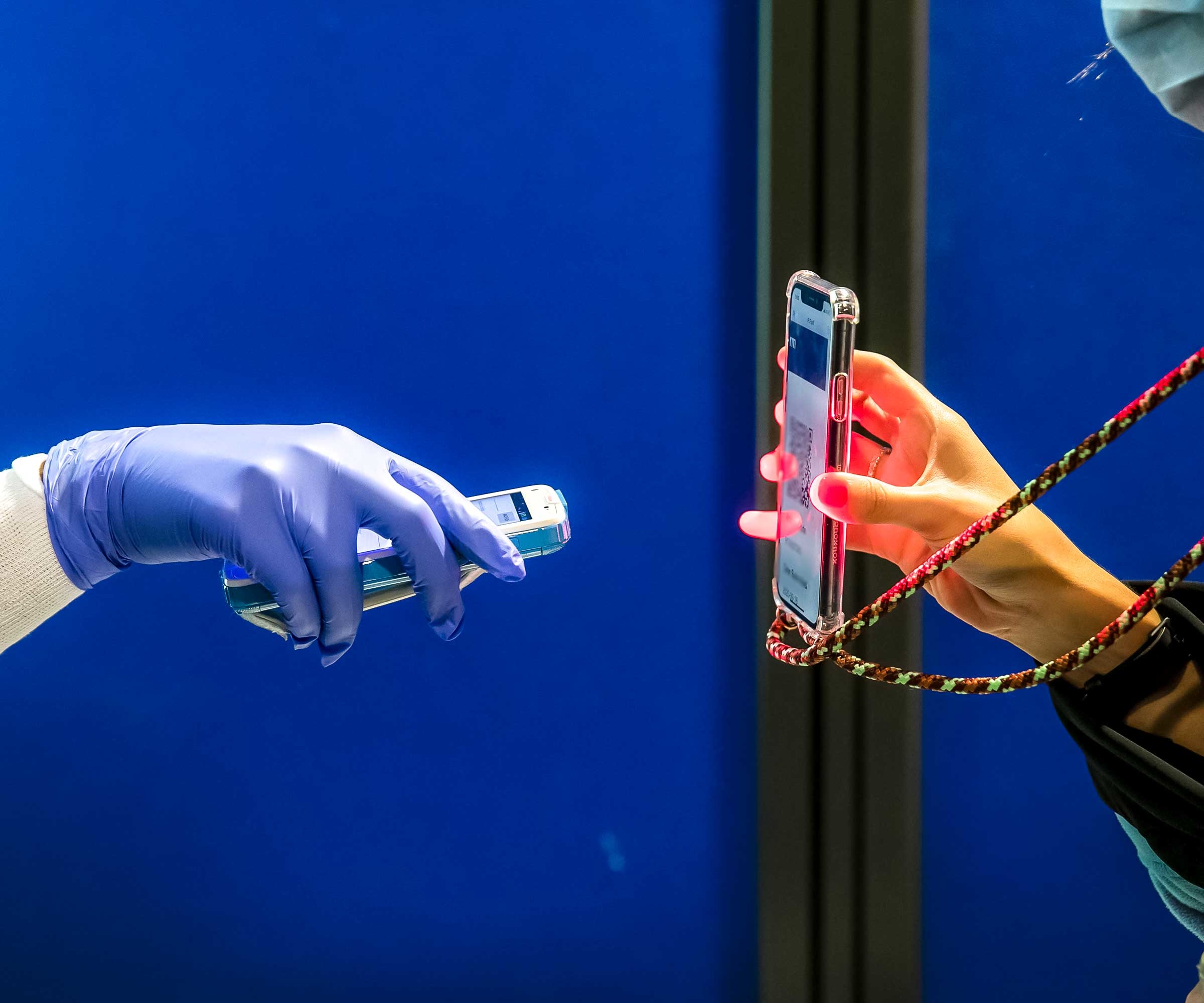 Prior to COVID-19 testing, a medic scans a traveler’s smartphone at Athens International Airport.  © Bloomberg/GettyImages