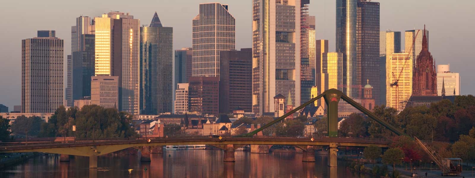 The skyline of Frankfurt is reflected on the river main at sunrise