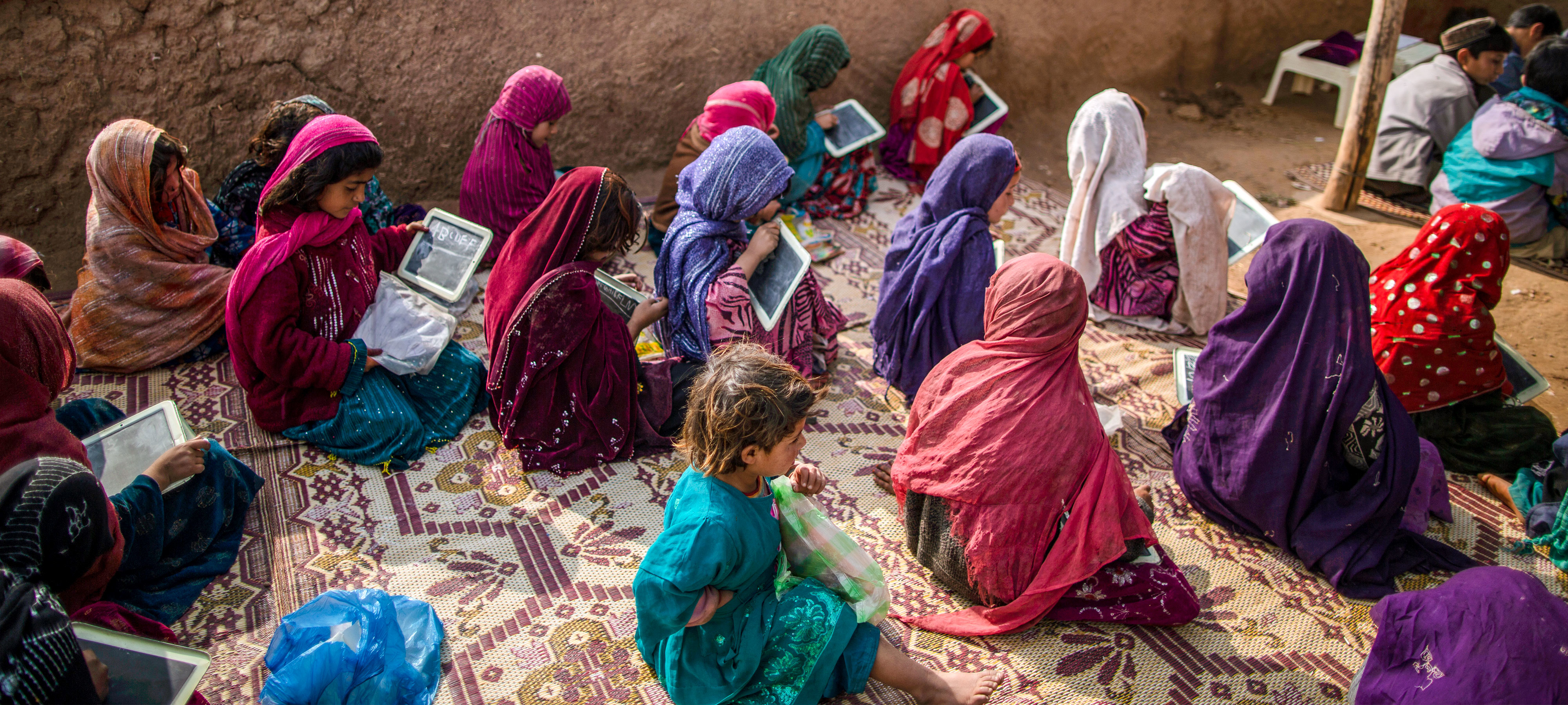 Afghan refugee children attend a class at a makeshift school set up in a mosque on the outskirts of Islamabad, Pakistan