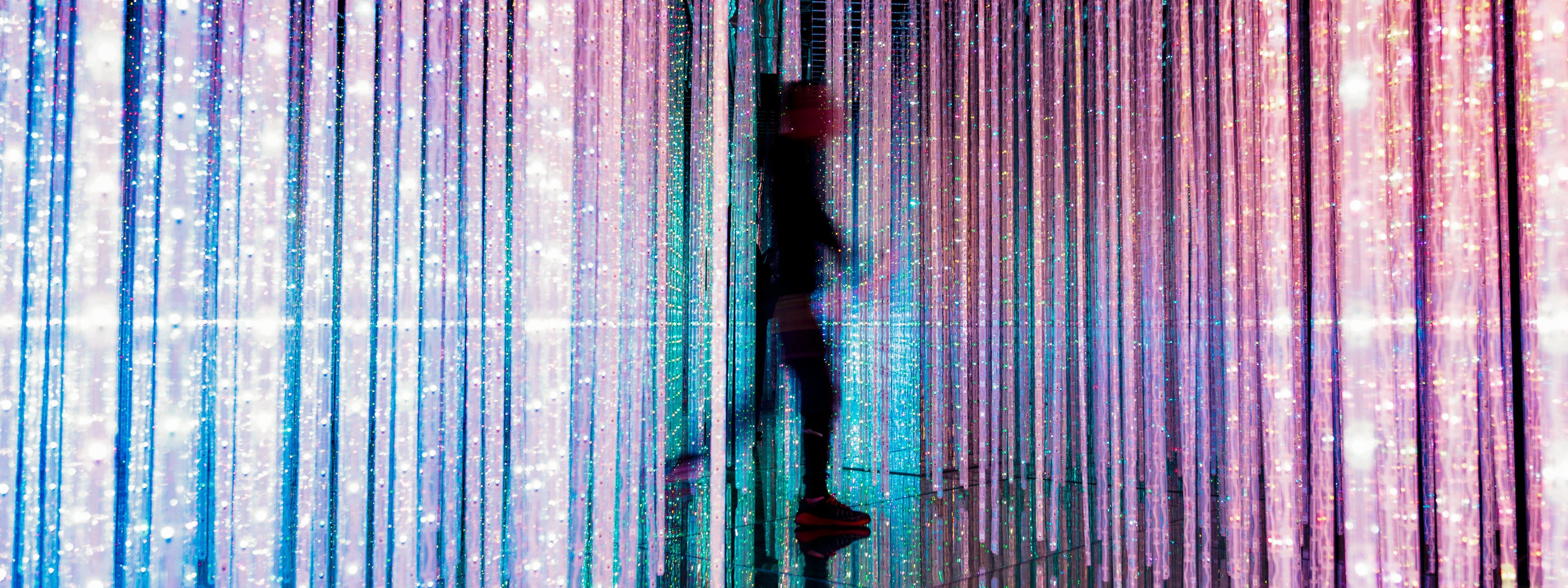 Person walking through strands of lights