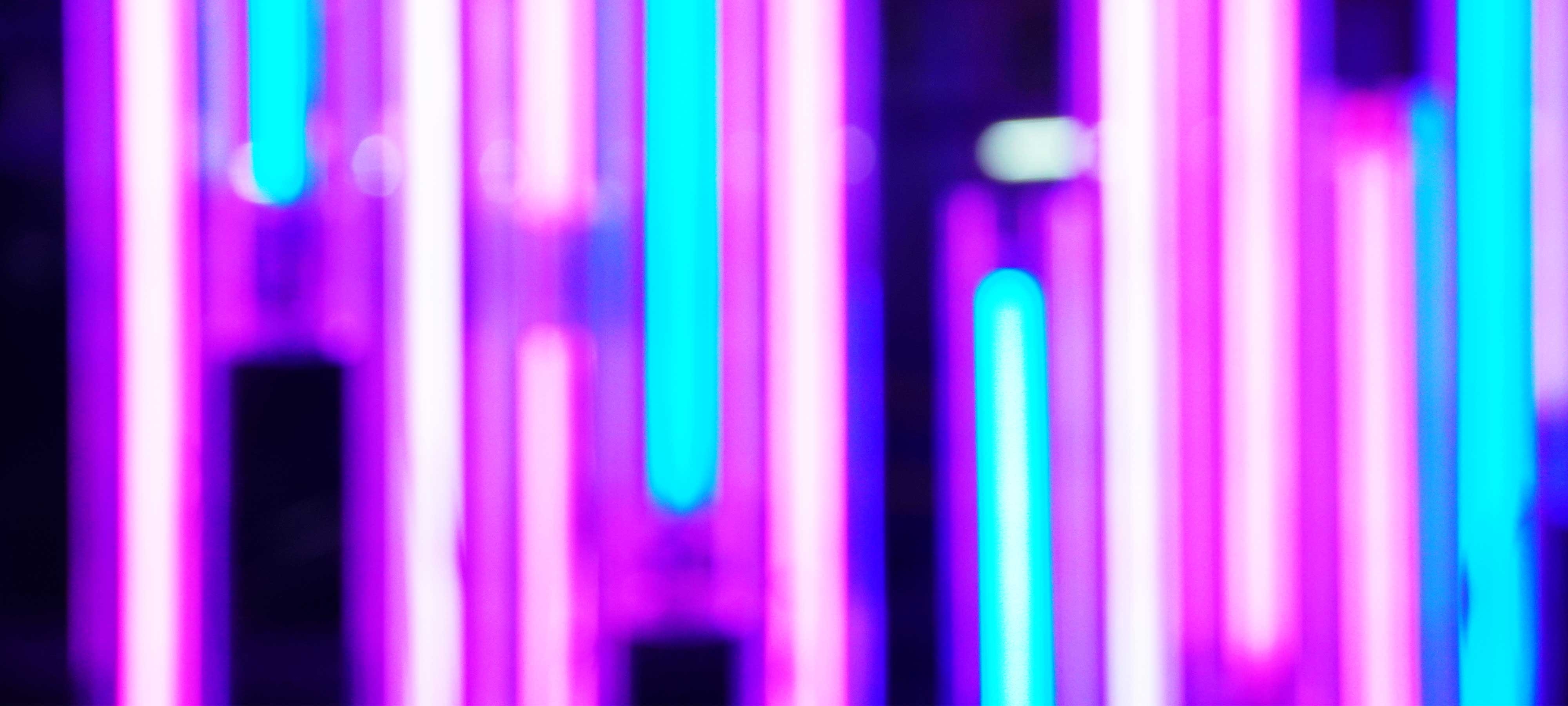 Blurred close-up of pink and turquoise neon lights
