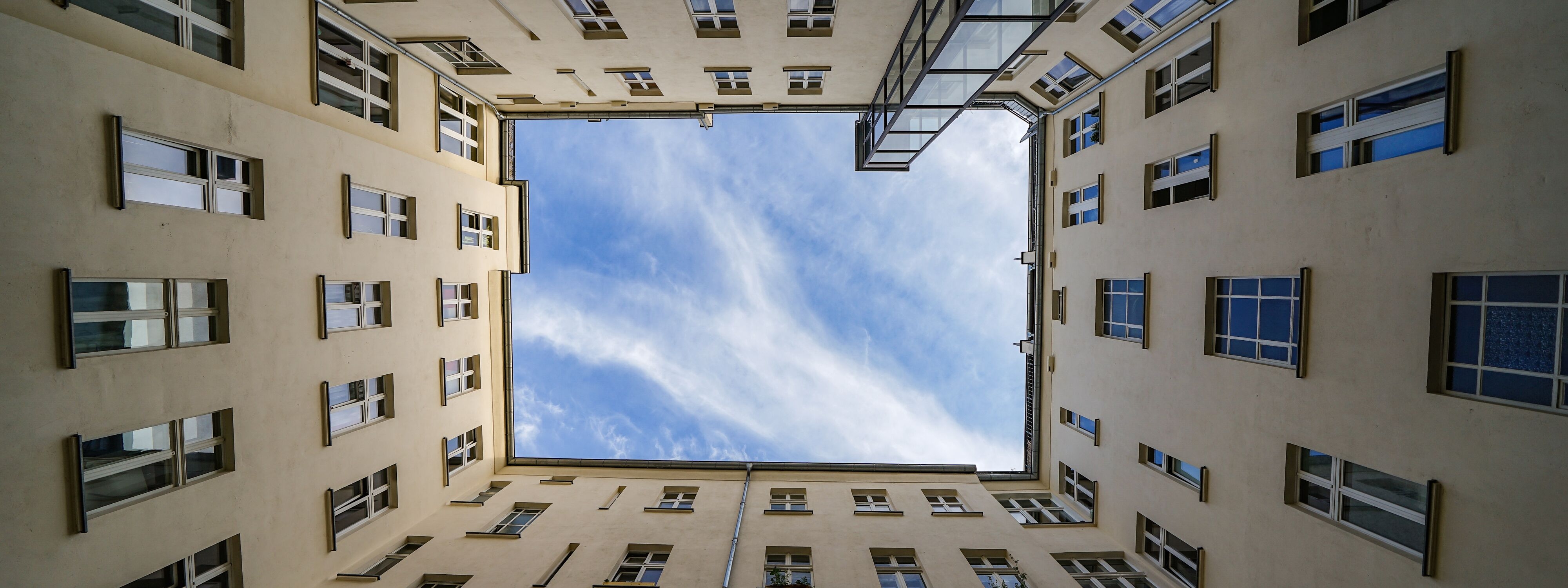 Directly below shot of building against cloudy sky